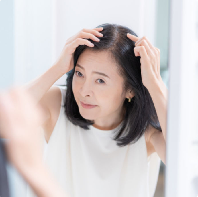髪の分け目を気にしている女性